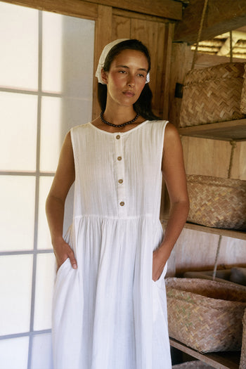 Nadi Dress White — front view upper body, white double gauze cotton midi dress with wooden button front and gathered waist, rustic bamboo interior | Daughters of India