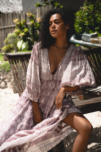 Jasmine Maxi Dress Lavender — outdoor lifestyle under thatched roof, tropical beach setting, full length showing tiered lavender maxi, hand block print cotton, artisan ethical boho maxi dress | Daughters of India